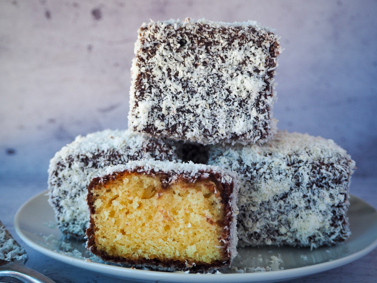 Lamingtons 1 Stack of three lamingtons with a lamington cut open in front.