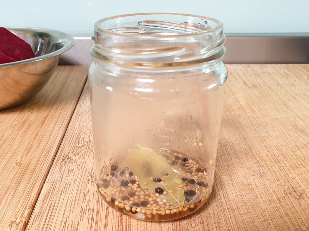 Refrigerator pickled beets 11 Side view first layer of spices, bay leaves and pickling liquid in jar.