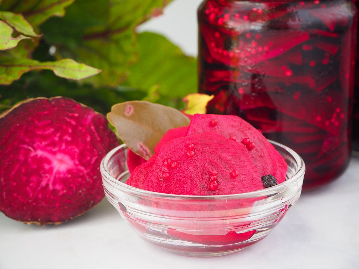 Refrigerator pickled beets 1 Small glass bowl refrigerator pickled beets with jar beets, fresh beet and beet leaves in the background.