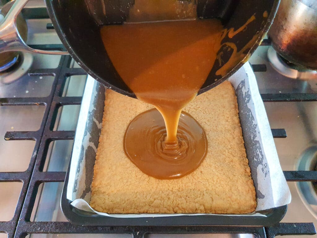 Ginger crunch 18 Pouring icing onto base.