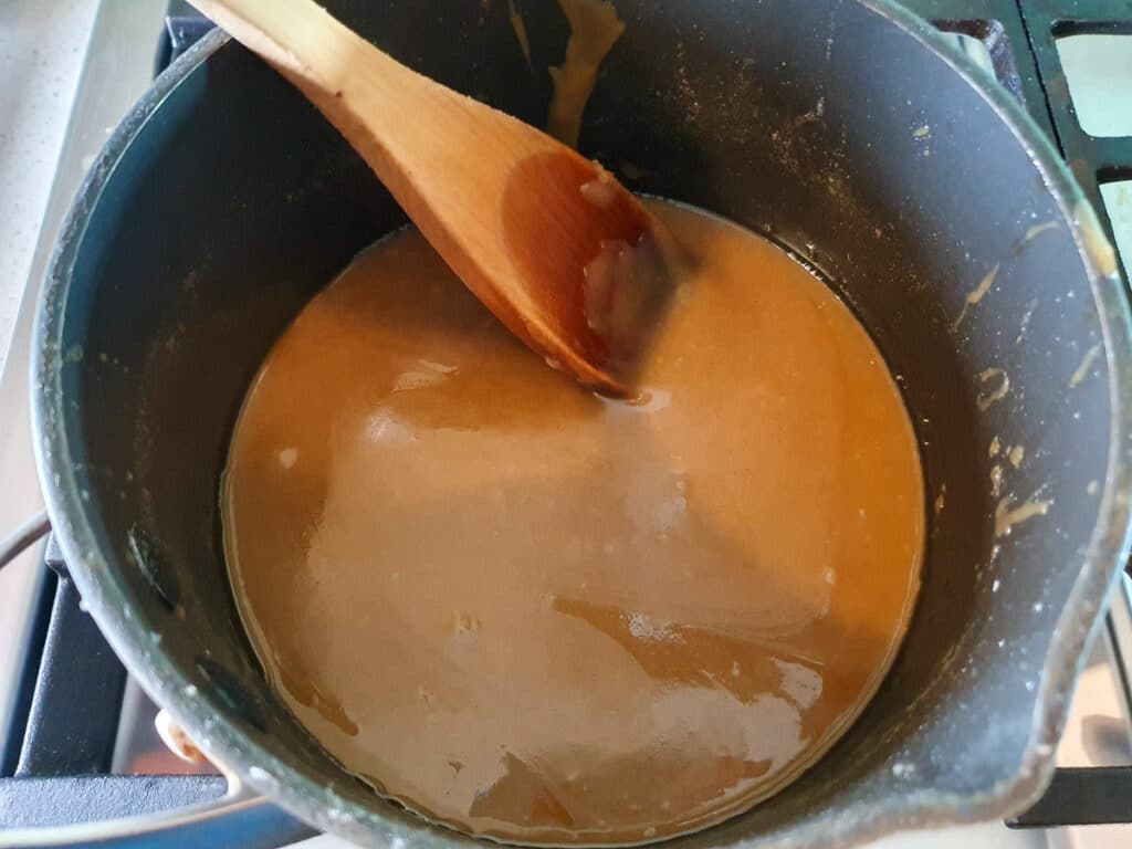 Ginger crunch 17 Stirring icing well in pot on stove.