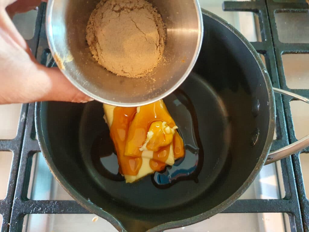 Ginger crunch 15 Adding ground ginger to pot on stove.