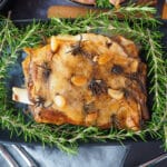 Slow cooker lamb shoulder 16 Close up slow cooker lamb roast on a serving plate, garnished with fresh rosemary.