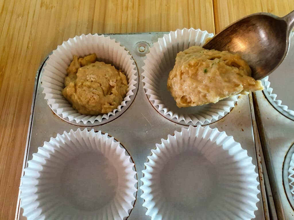 Feijoa muffins 13 Spooning mix into muffin tins.