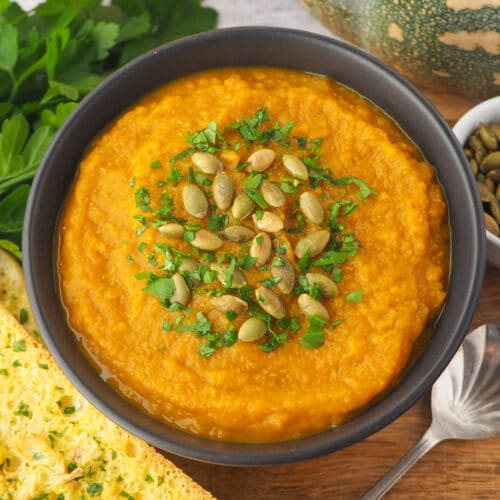 Pumpkin and Sweet Potato Soup 17 Close up soup with pumpkin seeds and parsley garnish.