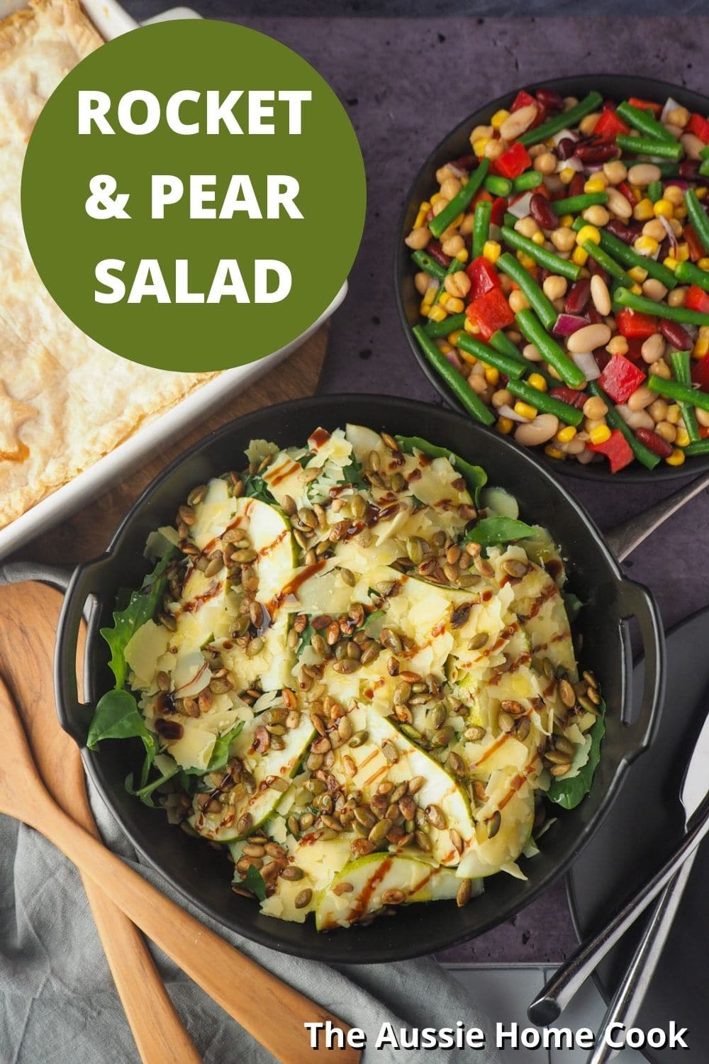 Rocket and Pear Salad 14 Salads with serving spoons and four bean salad and pie in the background, with text overlay, rocket and pear salad and The Aussie Home Cook.