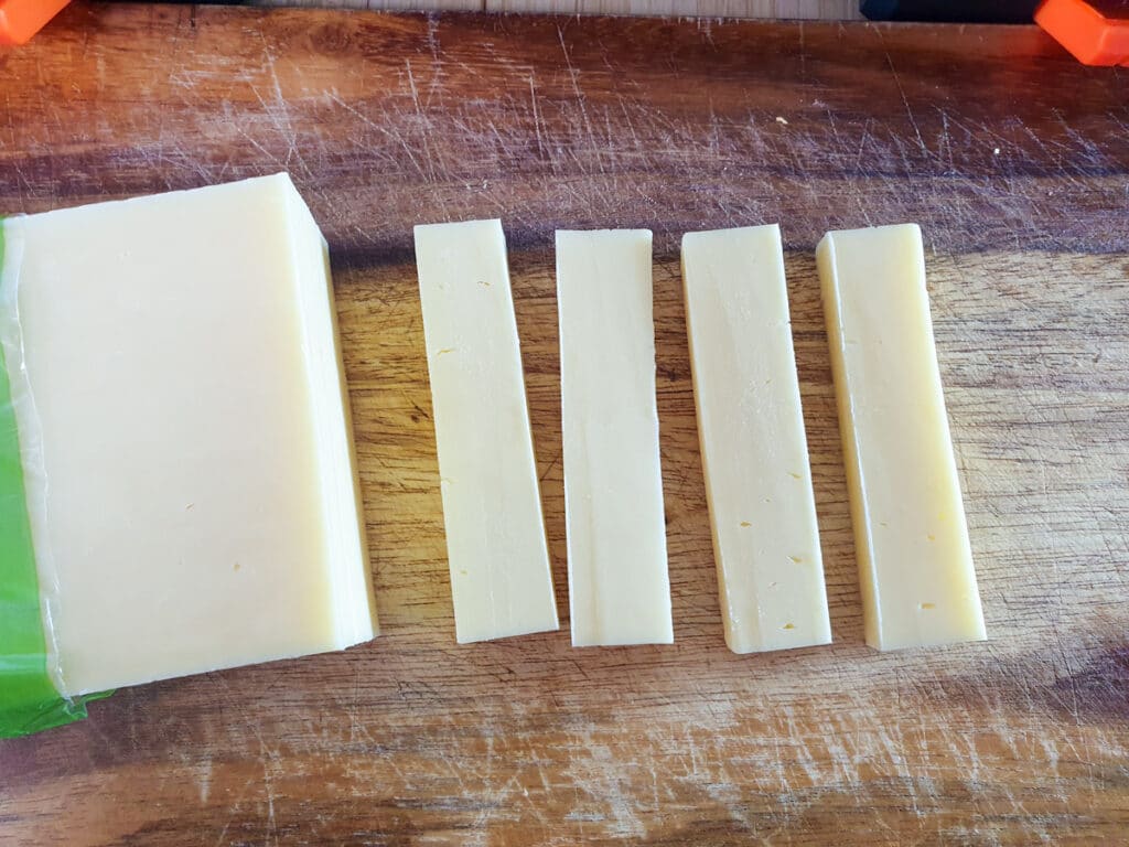 Picnic Charcuterie Board 8 Cutting cheese into cubes.