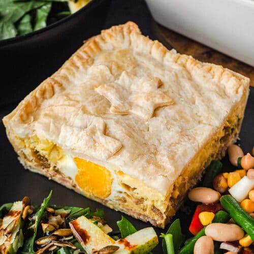 Bacon and Egg Pie 14 Close up pie in a plate with salads, with salads in background.