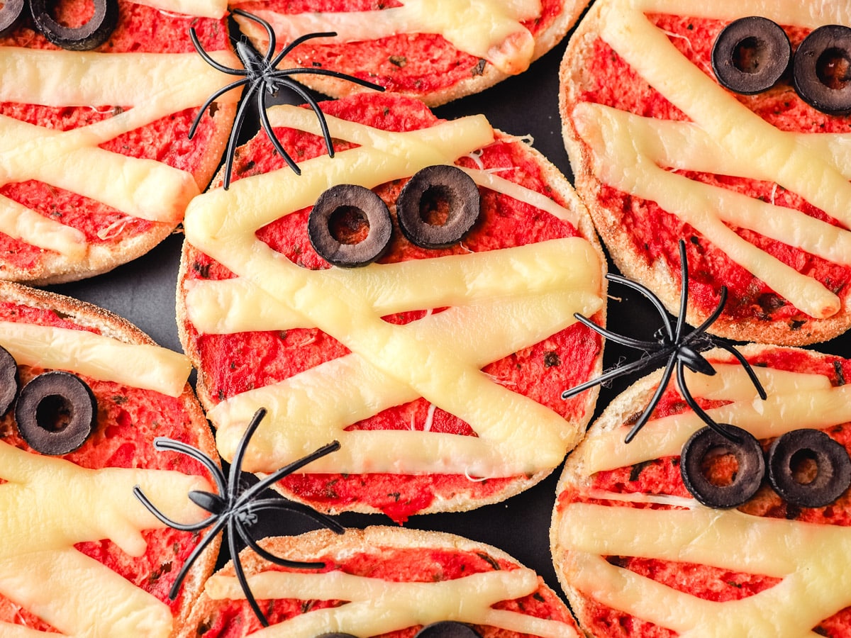 Mummy Pizzas 7 Pizzas on a plate with Halloween spider decorations.