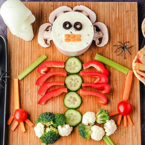 Skeleton Veggie Tray 12 Close up veggie tray on a board with Halloween skuls and spiders.